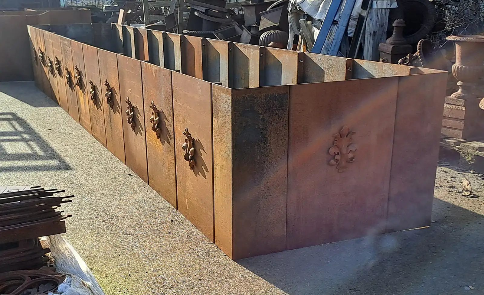 Hochbeet aus 4 mm Cortenstahl, 500x100 cm groß, 80 cm hoch, mit rostiger Oberfläche und Zierornamenten.